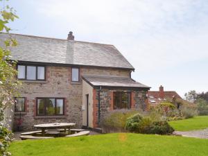 a brick house with a picnic table in front of it at Penhill Farm Cottage in Fremington