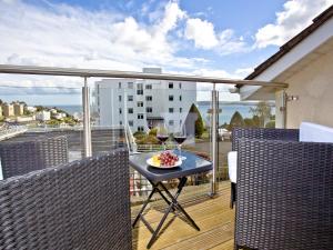 a balcony with a table with wine glasses on it at Sea Salt Lodge in Torquay