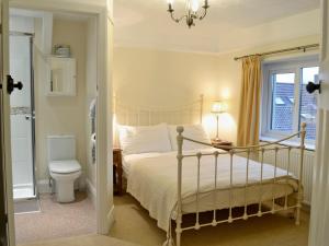 a bedroom with a bed and a toilet and a window at Penhill Farm Cottage in Fremington