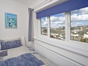 a bedroom with a bed and a large window at Sea Salt Lodge in Torquay