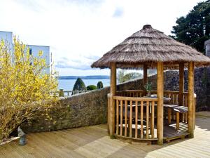 a gazebo with chairs and a straw roof at Sea Salt Lodge in Torquay