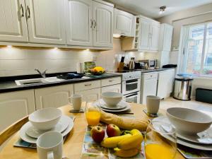 a kitchen with white cabinets and a table with fruit on it at The Coach House - 26154 in Corbridge