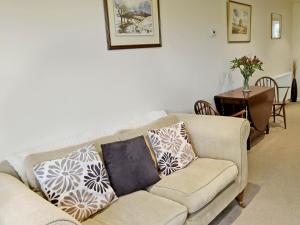 a living room with a couch with pillows on it at Whitethorn Lodge in Skipton