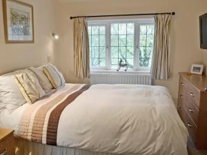 a bedroom with a bed and a cat in the window at Whitethorn Lodge in Skipton