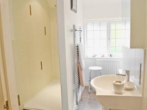 a white bathroom with a sink and a shower at Whitethorn Lodge in Skipton