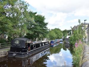 a boat is docked on the side of a canal at Whitethorn Lodge in Skipton