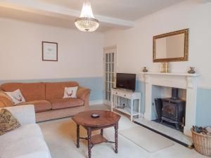 a living room with a couch and a fireplace at Ellinor House in Cleobury Mortimer