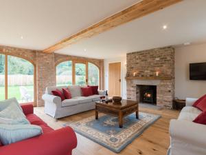 sala de estar con sofá y chimenea en White Lodge Cottage, en Carlton Miniott