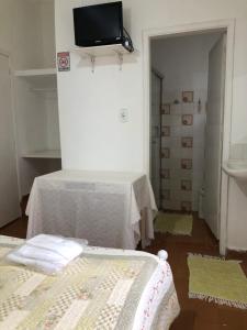 a room with two beds and a tv on the wall at Villa Interlagos de Minas in Guapé