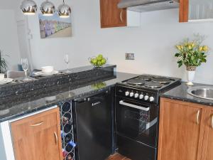 a kitchen with a black stove and a sink at Bryn Meurig in Abererch