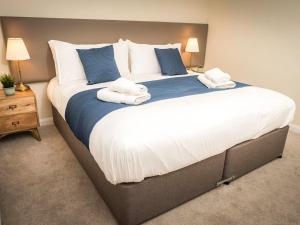 a large bed with two towels on top of it at Argyle View in Dunblane