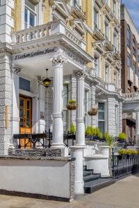 a white building with columns on a street at 1 Lexham Gardens Hotel in London