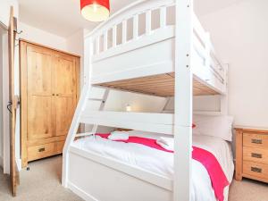 - une chambre avec des lits superposés blancs et une échelle dans l'établissement Shire Cottage - Uk37451, à Pateley Bridge