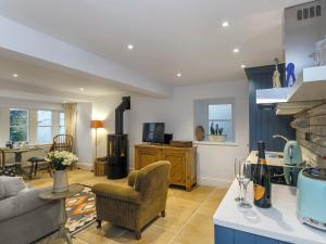 a kitchen and living room with a couch and a table at Healey Cottage in Kirkburton