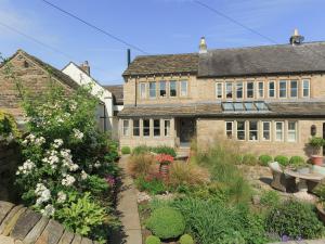 an old house with a garden in front of it at Healey Cottage in Kirkburton