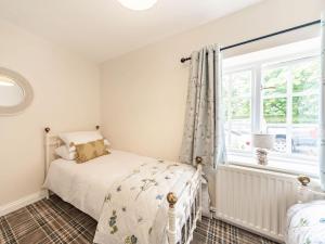 1 dormitorio con cama y ventana en Keepers Cottage, en Stocksfield