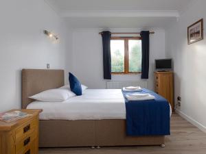 a bedroom with a large bed and a window at Mallard in Wroxham