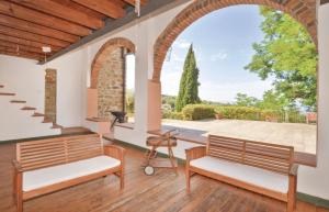 un patio al aire libre con 2 bancos y un arco en Villa Ari, la tua villa in Toscana, en Reggello