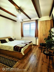 um quarto com uma cama grande e uma janela em Vatra Strabunilor em Moigrad