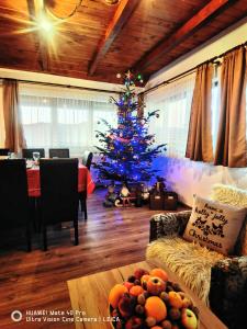 a blue christmas tree in a living room with a table at Vatra Strabunilor in Moigrad