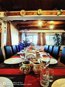 uma mesa com copos de vinho e uma árvore de Natal em Vatra Strabunilor em Moigrad