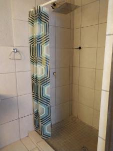 La salle de bains est pourvue d'une douche avec une porte en verre. dans l'établissement Tsamatiku Villa Guesthouse, à Hazyview