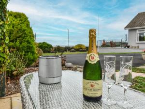 a bottle of champagne sitting on a table with glasses at Lynch Annexe in Appledore