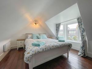 a bedroom with a bed and a window at Pink Cottage in Nairn