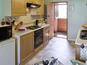 a kitchen with wooden cabinets and a stove top oven at Allt Maen - E3266 in Lowick Green