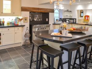 a kitchen with a large island with bar stools at Slowpool 