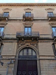 a tall building with two balconies and a door at Luxury apartment in the center of Catania in Catania