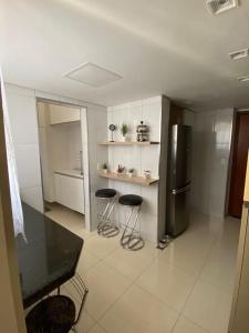 a kitchen with two stools and a stainless steel refrigerator at ENCANTADOR , MODERNO E CONFORTÁVEL !!! in Belo Horizonte +7 photos