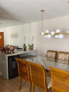 a kitchen with a table and chairs and a counter at ENCANTADOR , MODERNO E CONFORTÁVEL !!! in Belo Horizonte