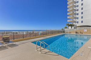 a swimming pool with the beach in the background at The Palms #1002 in Orange Beach