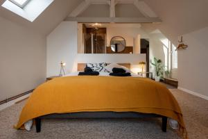 a bedroom with a large bed with a yellow blanket at La Villégiature in Coutances