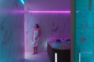 uma mulher de pé numa casa de banho com um lavatório em Life Hotel Seaview & Spa em Porto Recanati