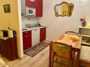 a kitchen with red cabinets and a table and a mirror at Kurhaus Apartment King Size Bett 180x200 in Bad Harzburg