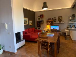 een woonkamer met een rode bank en een tafel bij Casa Gino Petrulli Etna, villa con piscina in Zafferana Etnea