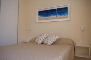 1 dormitorio con 1 cama con 2 almohadas en Departamento Solares de Cofico - Terraza Privada en Córdoba