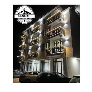 ein Gebäude mit davor geparkten Autos in der Unterkunft GENCIAN RESORT in Kopaonik