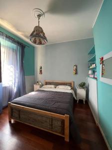 1 dormitorio con cama y pared azul en Appartamenti LA MAGNOLIA en Arrone