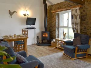 sala de estar con chimenea, mesa y sillas en Barn Cottage - Ukc2682, en Poundstock