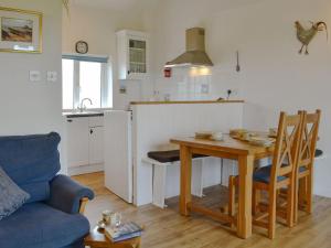 a living room with a table and a kitchen at Barn Cottage - Ukc2682 in Poundstock