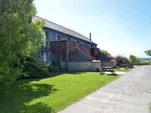 a building with a picnic table in the grass at Barn Cottage - Ukc2682 in Poundstock