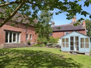 a house with a greenhouse in the yard at Repton Cottage - 25348 in Findern