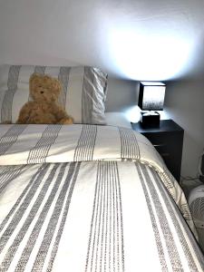 a teddy bear sitting on top of a bed at Single room bentilee in Bucknall