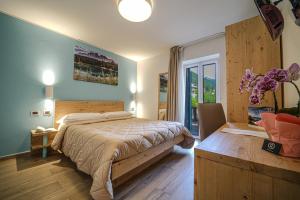 um quarto com uma cama grande e uma janela em GH Hotel Monzoni em Pozza di Fassa