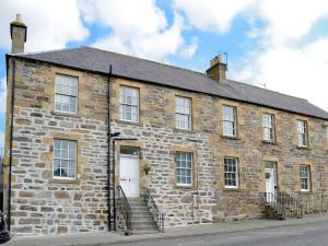 an old stone building with stairs on a street at Seafield Street in Cullen