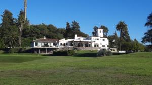 una gran casa blanca en un campo de golf en La Posta San Fernando en Villa Allende