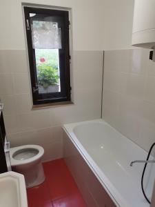 a white bathroom with a toilet and a window at Ubytovanie Liptov in Liptovský Michal